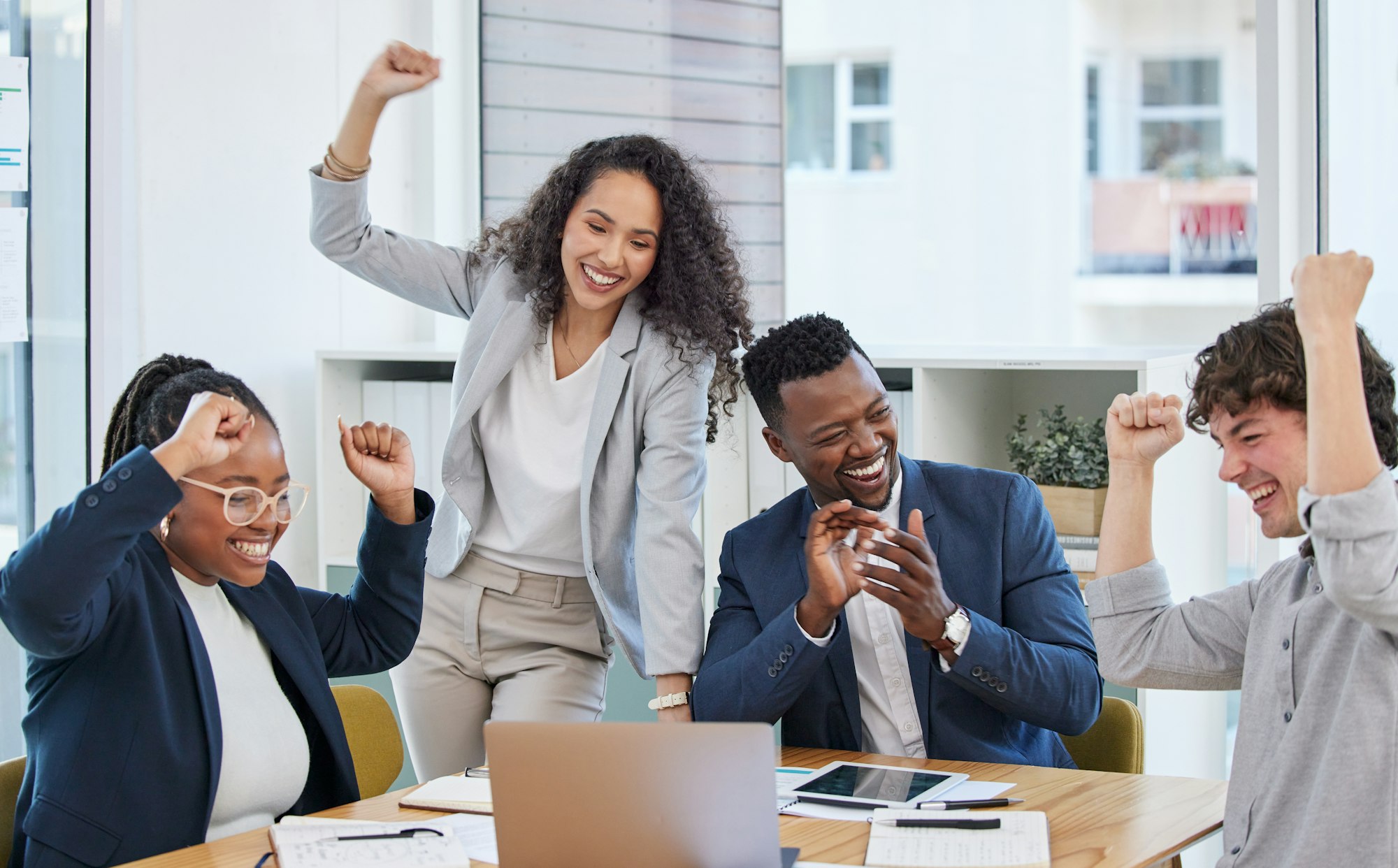 Succeeding in their mission as a team. Shot of a group of businesspeople cheering in an office.