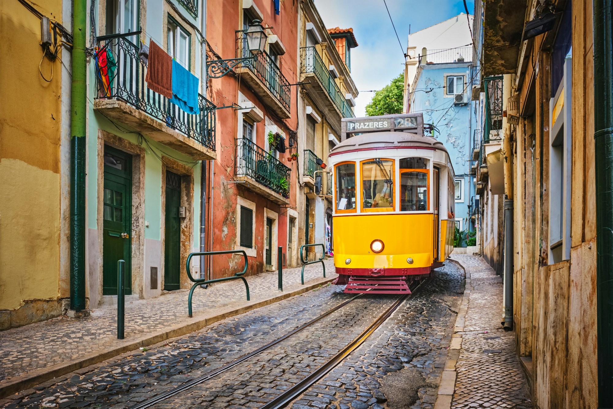 Famous vintage yellow tram 28 in the narrow streets of Alfama district in Lisbon, Portugal