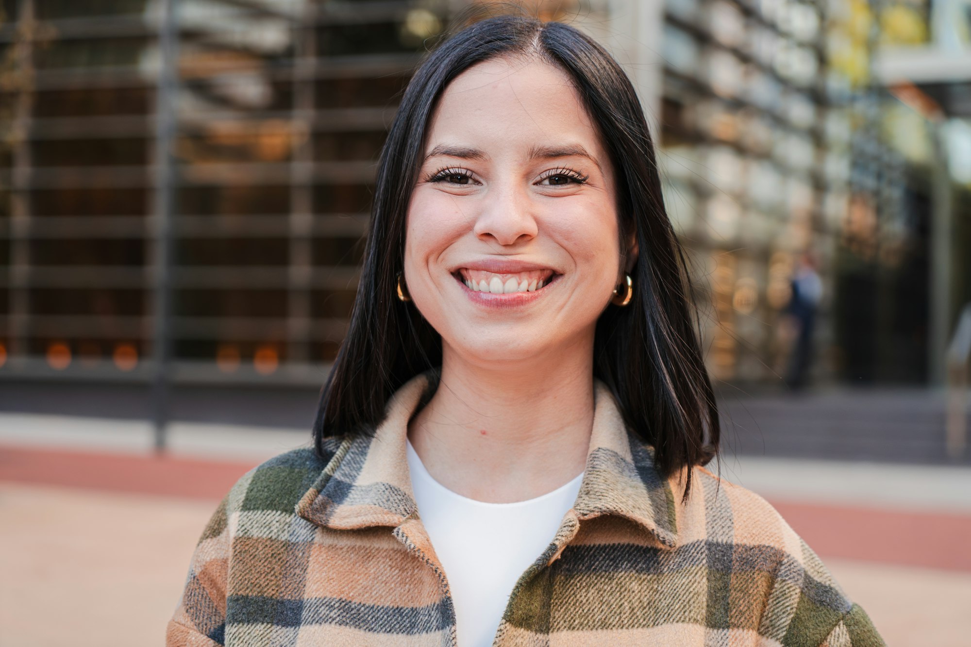 One hispanic woman looking at camera with friendly expression. Close up individual portrait of a