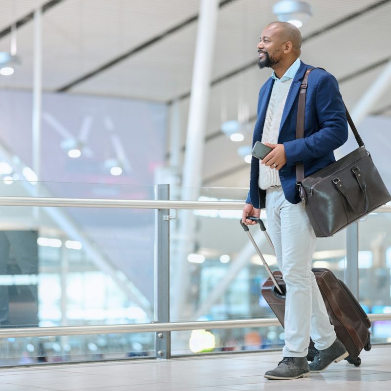 Corporate, black man in airport and travel for conference, workshop and ceo with happiness and tour