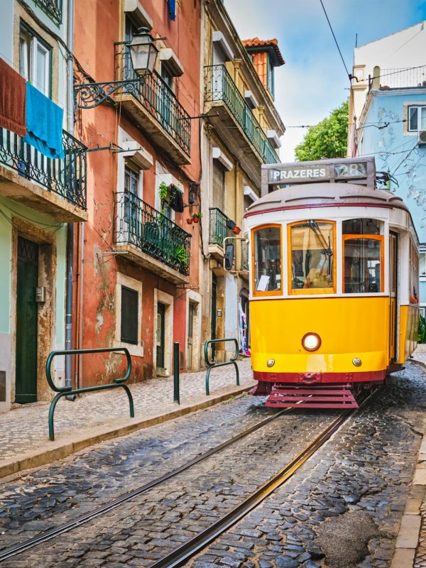 Famous vintage yellow tram 28 in the narrow streets of Alfama district in Lisbon, Portugal