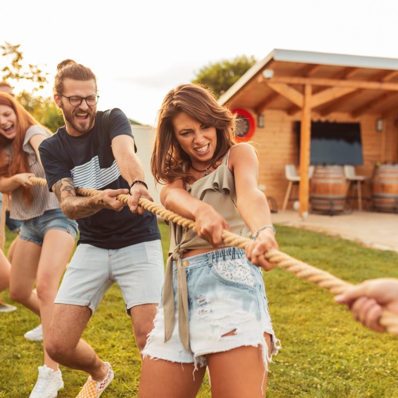 People playing tug of war while on team building trip